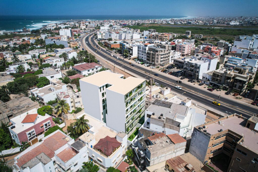 Vue montrant l'arrière-façade de la Résidence Safiétou et sa situation avec la route de l'aéroport Léopold Sédar Senghor