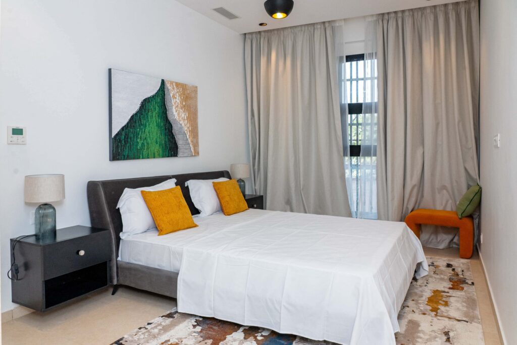 chambre de la résidence siki joliment aménagée avec une parure lit blanche et jaune.