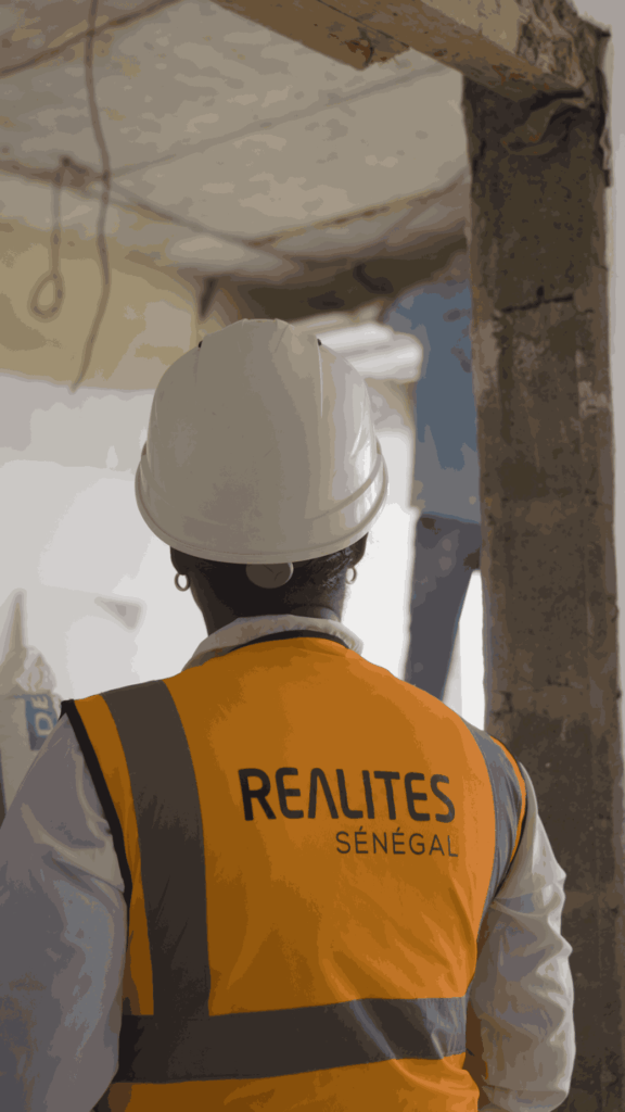 conductrice de travaux REALITES SENEGAL avec casque de chantier