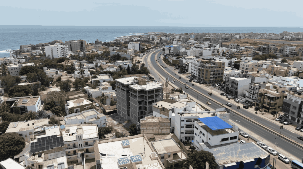 Vue sur la résidence Safiétou en cours de construction et la VDN. L'océan Atlantique à l'horizon.